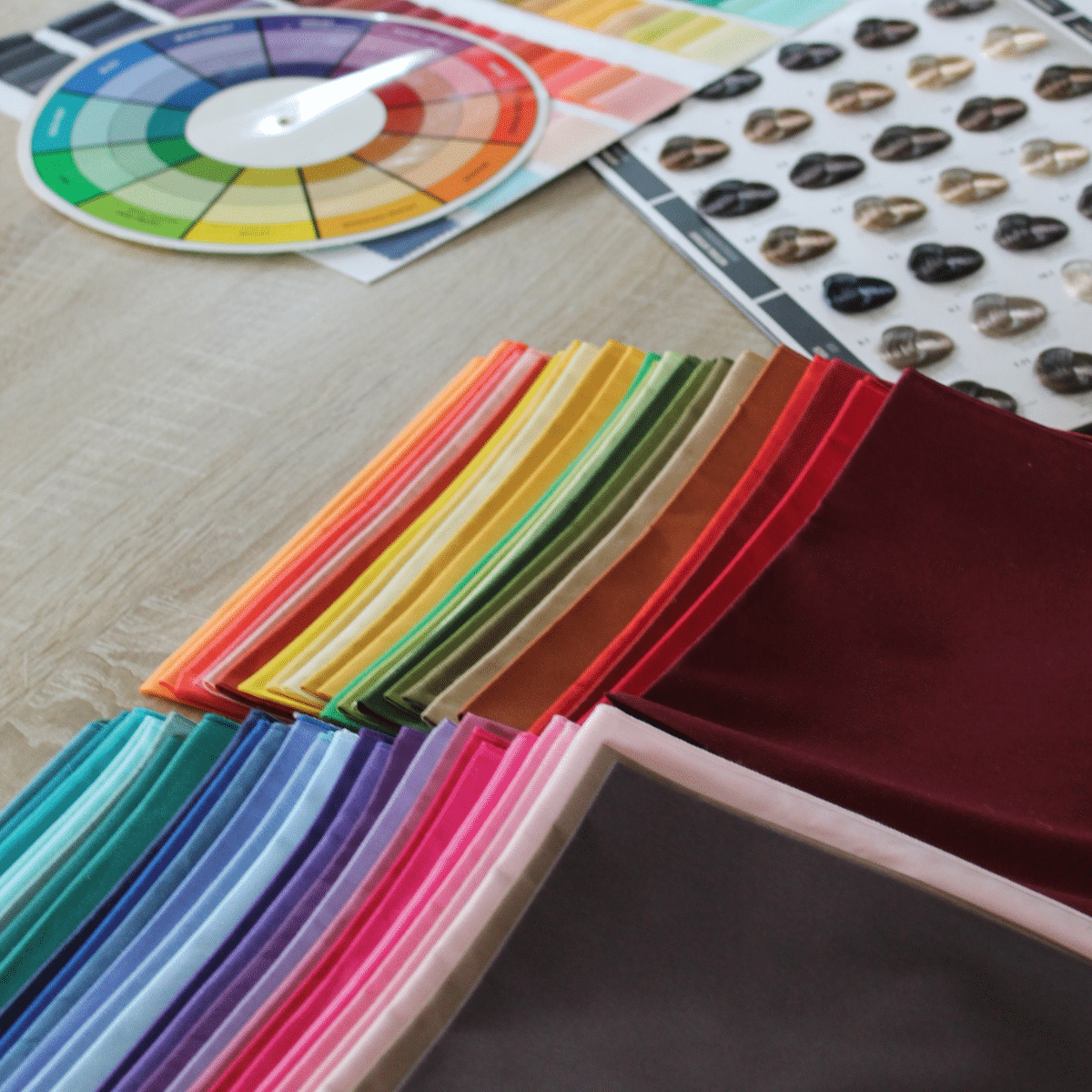 Drapings colorés, roue chromatique et nuancier disposés sur une table lors d'un atelier de colorimétrie