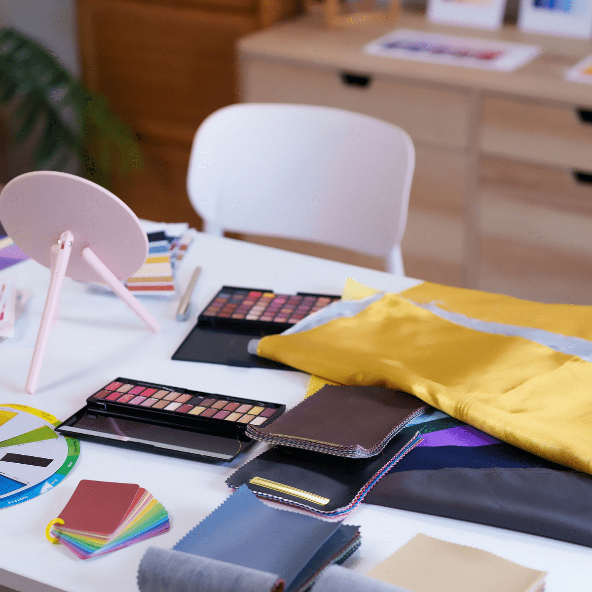 Table d'atelier de colorimétrie à Nice, palettes de maquillage, drapings et nuanciers